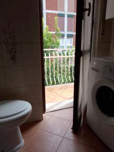 a bathroom with a toilet and a door to a balcony at Casafiorella in Monza +4 photos