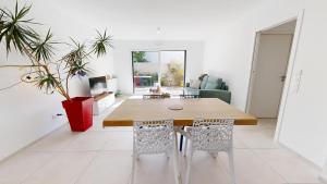 ein Wohnzimmer mit einem Holztisch und Stühlen in der Unterkunft Casa 3 Merlyne Plage in Saint-Gilles-Croix-de-Vie + 22 Fotos