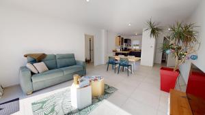 ein Wohnzimmer mit einer blauen Couch und einer Küche in der Unterkunft Casa 3 Merlyne Plage in Saint-Gilles-Croix-de-Vie
