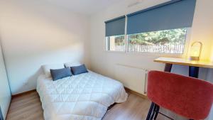 ein Schlafzimmer mit Bett, Schreibtisch und Fenster in der Unterkunft Casa 3 Merlyne Plage in Saint-Gilles-Croix-de-Vie