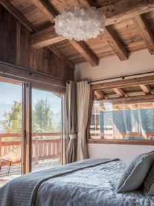 ein Schlafzimmer mit einem Bett und einem großen Fenster in der Unterkunft Chalet Marianna I Le Chalet Club in Combloux