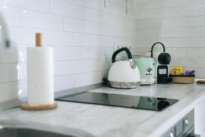 a kitchen counter with a sink and a tea kettle at Bernabéu Business & Stay in Madrid