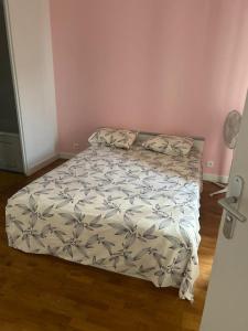 ein Bett in einem Schlafzimmer mit einer Tagesdecke darauf in der Unterkunft Omega Appartment in Corbeil-Essonnes