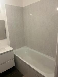 ein weißes Badezimmer mit Badewanne und Waschbecken in der Unterkunft Omega Appartment in Corbeil-Essonnes