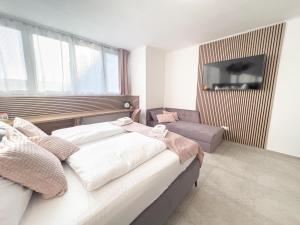 a bedroom with a bed and a couch and a television at Modern & Air condition 5BR, Near Danube River in Krems an der Donau