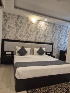 Un dormitorio con una cama grande con una pared. en Hotel Raveena 12, en Nueva Delhi