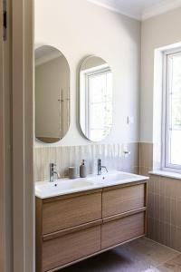 a bathroom with a sink and two mirrors at Villa Svinninge in Åkersberga +29 photos