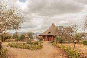 an old hut in the middle of a dirt road at Naramatisho Womens Centre & Maasai Cultural Stay in Makuyuni