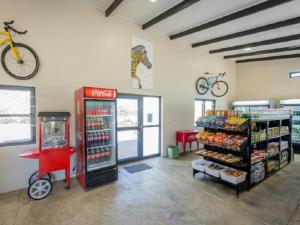 a store with a coke machine and a bike on the wall at Nauams Namibia - Farmyard Chalets, Mountain Cabins and Campsite in Namibgrens