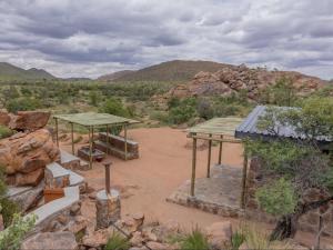 a building in the middle of a desert with mountains at Nauams Namibia - Farmyard Chalets, Mountain Cabins and Campsite in Namibgrens