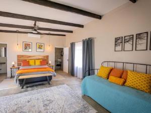 a bedroom with a bed and a couch at Nauams Namibia - Farmyard Chalets, Mountain Cabins and Campsite in Namibgrens