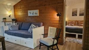 科特卡Santalahti Resort Cottages & Villas的一间有一张床和一把椅子的小房间