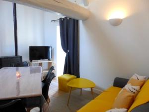 ein Wohnzimmer mit einem gelben Sofa und einem Tisch in der Unterkunft Maison typique à Broût-Vernet avec animaux admis - FR-1-489-68 in Broût-Vernet