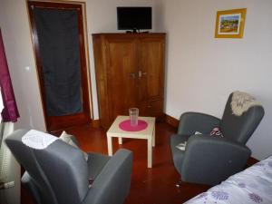 een woonkamer met twee stoelen en een tafel bij Gîte familial avec jardin, terrasse, vélos, Wifi, et animaux acceptés near Saint Pol sur Ternoise - FR-1-376-47 in Fiefs