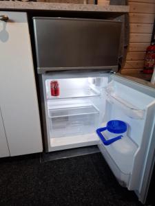 an empty refrigerator with its door open in a kitchen at Onnela Homestay Sauna Cottage in Rovaniemi