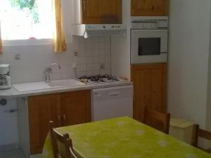 eine Küche mit Tisch, Spüle und Herd in der Unterkunft Charmant Gîte Familial à 1km de la Plage avec Jardin, Wifi et Cheminée, Côte d'Opale - FR-1-376-102 in Wimille + 3 Fotos