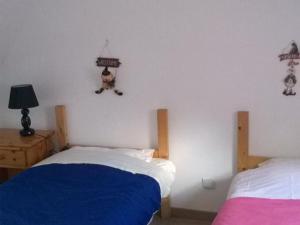 ein Schlafzimmer mit 2 Betten und eine Katze hängt an der Wand in der Unterkunft Charmant Gîte Familial à 1km de la Plage avec Jardin, Wifi et Cheminée, Côte d'Opale - FR-1-376-102 in Wimille