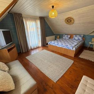 a bedroom with a bed and a tv and a couch at Cabana 23 - Avrig in Avrig