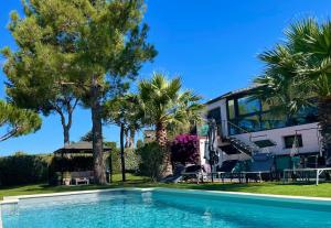 een huis met een zwembad en palmbomen bij L'ESCALE COTE BLEUE VILLA & Spa Classée 4 Étoiles in Sausset-les-Pins