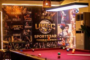 a room with a pool table and posters on the wall at The Stackey Hotel in Olongapo