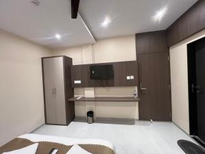 Cette chambre comprend une cuisine avec un bureau et une télévision. dans l'établissement CR Residency By Glitz Hotels, à Mumbai