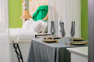 a table with plates and glasses on it with a bed at The Stackey Hotel in Olongapo