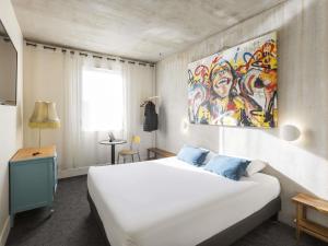 Un dormitorio con una cama blanca y un cuadro en la pared. en Greet Hotel Limoges Nord, en Limoges 96 fotos más