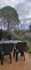 Una mesa y sillas en un patio. en Le laurier, en Bourg-Saint-Andéol
