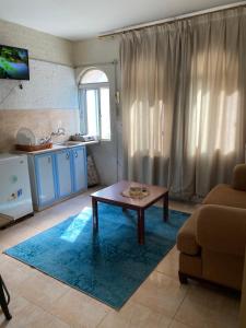 a living room with a table and a kitchen at Sami Apartments in Amman
