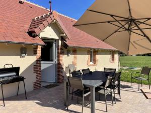 a table and chairs and an umbrella on a patio at Gîte HUGO Domaine de la Pierre - FR-1-489-339 in Thiel-sur-Acolin