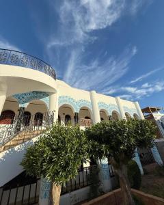 a white building with trees in front of it at yasmina hotel in Dahab