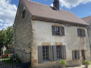 an old stone house with a black fence at Charmant Gîte de Campagne avec Confort et Détente - FR-1-489-348 in Besson