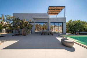 a patio with a table and a swimming pool at Villa Faros in Egina