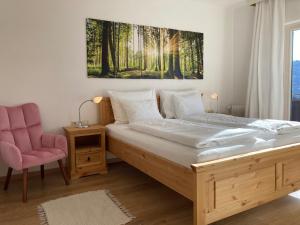 a bedroom with a large bed and a pink chair at Haus Werner, Ferienwohnung mit Sommercard in Ramsau am Dachstein