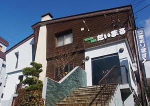 un bâtiment avec une enseigne sur le côté dans l'établissement 苗場ウッドインだいまる, à Yuzawa