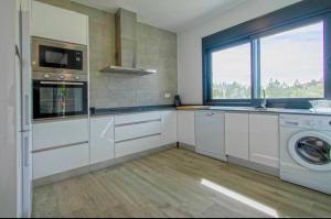 a kitchen with a washing machine and a window at OLE TÚ ANDALUCIA in Sanlúcar la Mayor