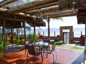 a patio with a table and chairs and the ocean at Flat Pietra in Florianópolis