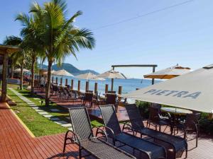 a row of chairs and umbrellas on a beach at Flat Pietra in Florianópolis