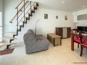 un salon avec un canapé et un escalier dans l'établissement Maison rénovée en Suisse Normande, animaux admis et Wi-Fi - FR-1-497-242, à Saint-Pierre-du-Regard