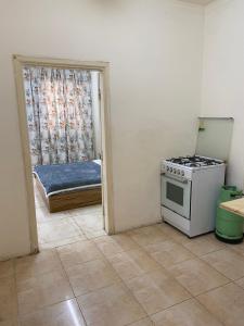 a kitchen with a stove and a bedroom with a bed at Sami Apartments in Amman
