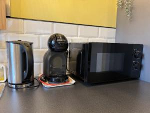 een koffiezetapparaat en een magnetron op een aanrecht bij Penthouse in Kohila in Kohila