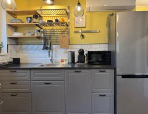 een keuken met witte kasten en een roestvrijstalen koelkast bij Penthouse in Kohila in Kohila +23 foto's