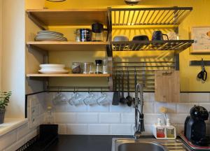 een keuken met een wastafel en een plank met borden bij Penthouse in Kohila in Kohila