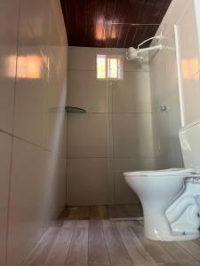 a bathroom with a toilet and a glass shower at Nordestino in Pipa