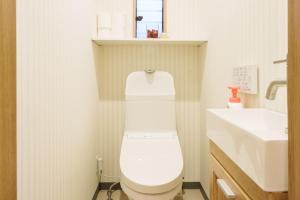 a bathroom with a white toilet and a sink at Tenjinbashi-suji Shopping Street Guesthouse Entire House Direct train access to 道頓堀 黒門市場 USJ Kansai International Airport in Osaka +75 photos