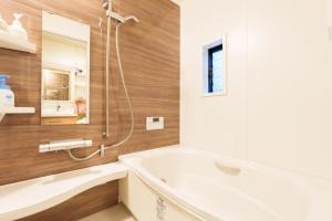a bathroom with a bath tub and a sink at Tenjinbashi-suji Shopping Street Guesthouse Entire House Direct train access to 道頓堀 黒門市場 USJ Kansai International Airport in Osaka