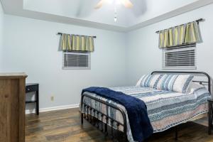 a bedroom with a bed and two windows at New to listing Dorsey Dock Retreat w Dock in Hartwell