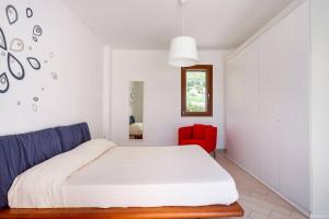 een slaapkamer met een bed en een rode stoel bij Villa delle Stelle in Scopello +37 foto's