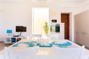 een witte eetkamer met een witte tafel en stoelen bij Villa delle Stelle in Scopello