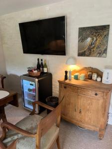a living room with a television and a refrigerator at Winding B&B Silkeborg in Silkeborg
